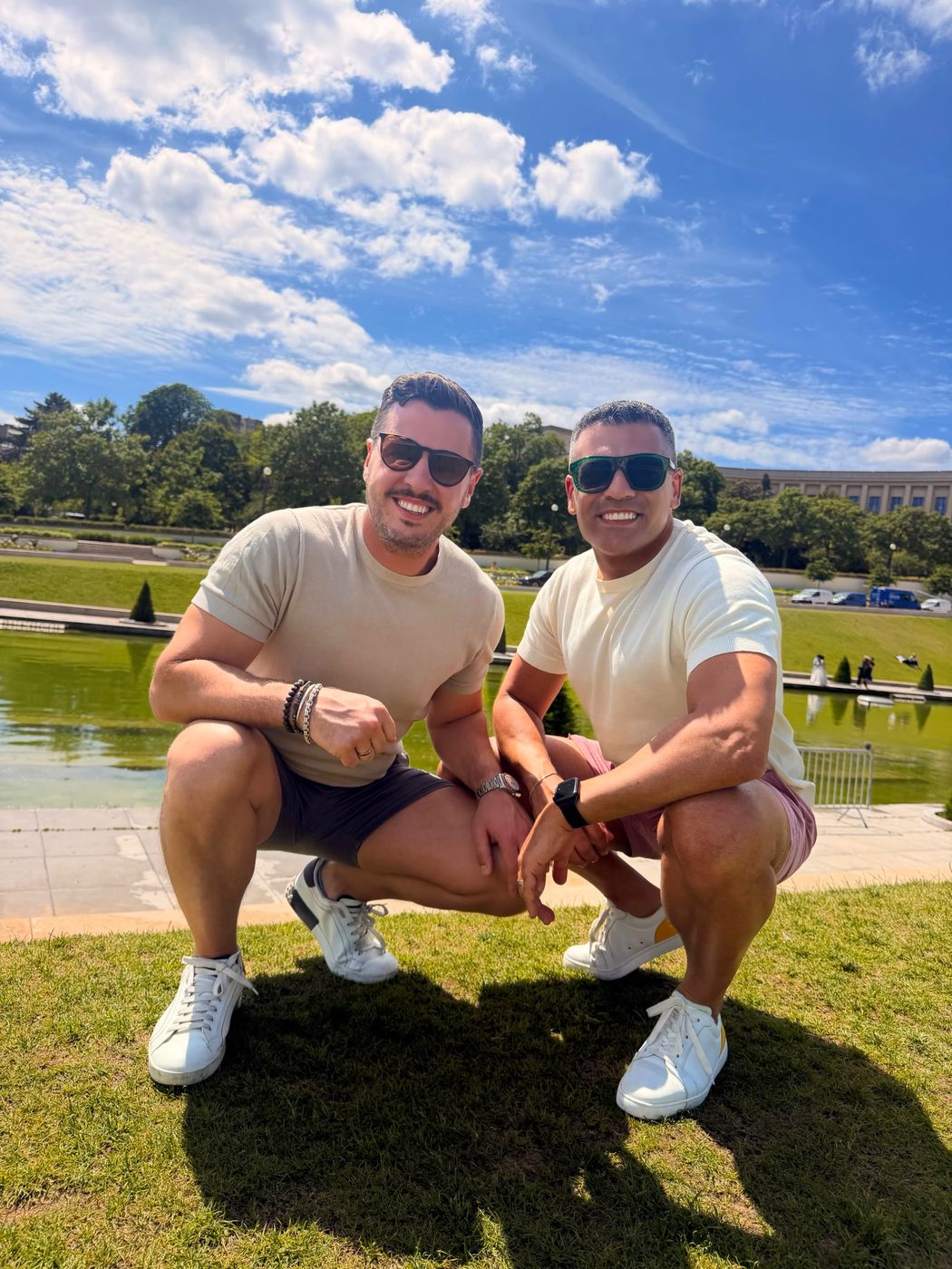 Elie and Justin crouching on the lawn at the Trocadéro gardens on a sunny day